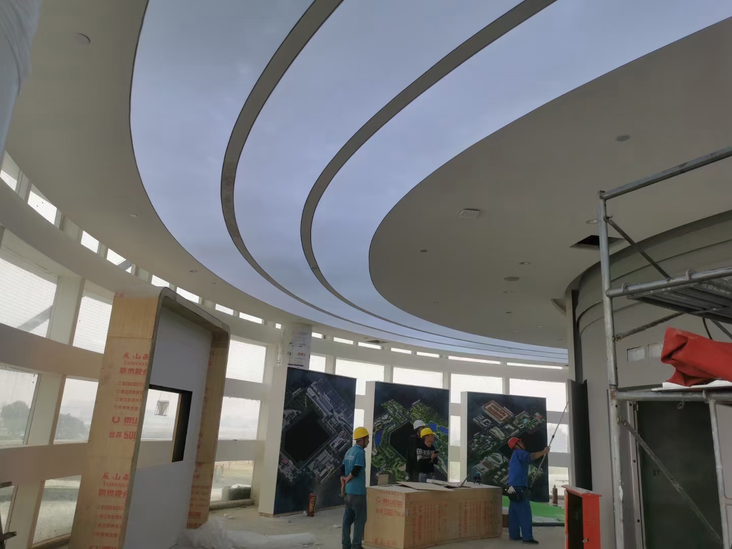 围绕建筑圆柱布置的环形透光软膜天花，白色弧形发光面与圆弧造型吊顶相结合.jpg
