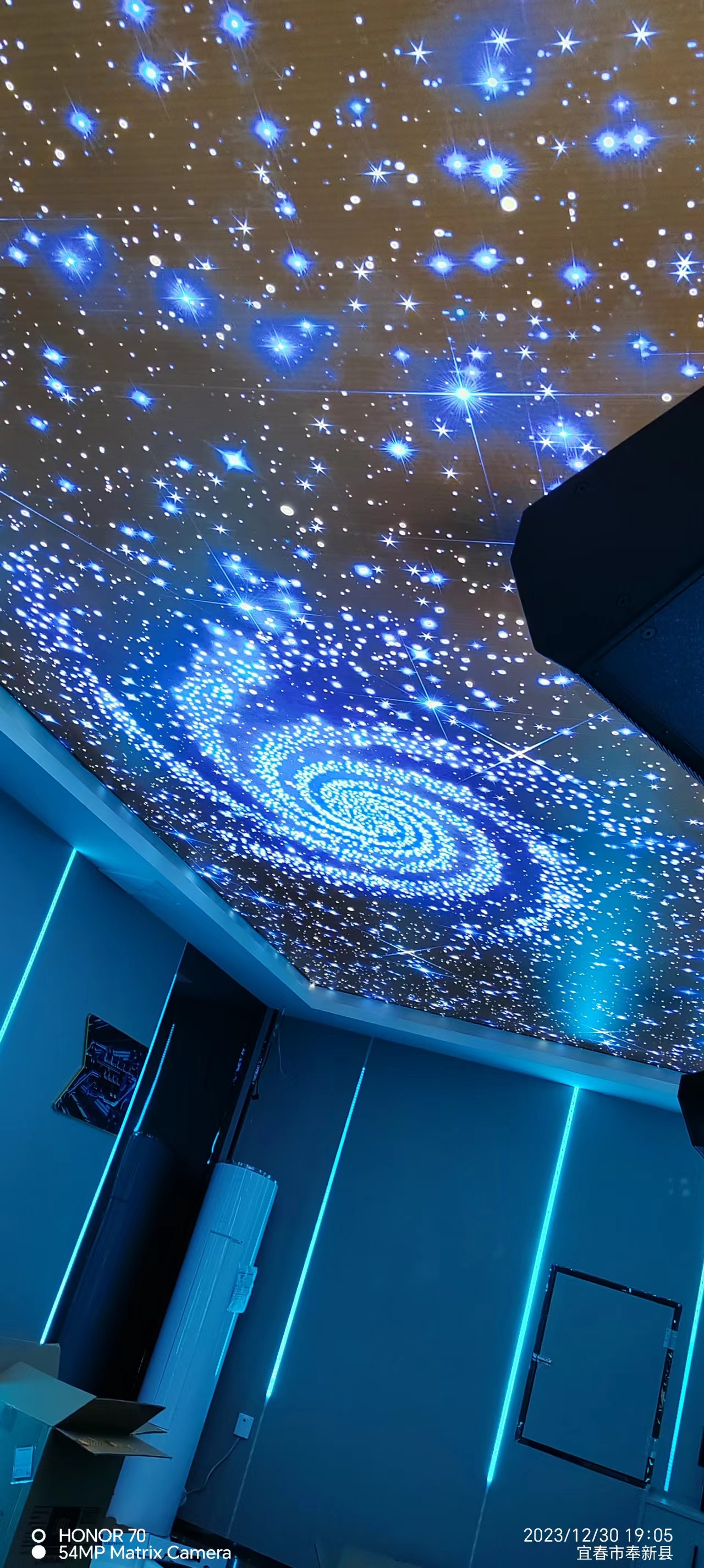 奉新县KTV蓝色银河星空软膜吊顶现场.jpg KTV包厢蓝色银河旋涡星空软膜吊顶,顶部繁星图案搭配墙面蓝色线性灯带
